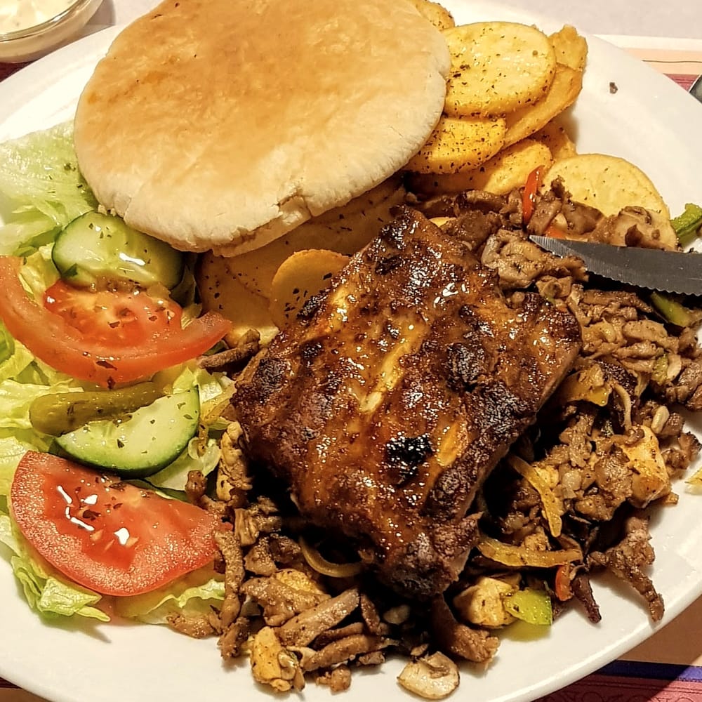 Grillschotel met spareribs, gekruid vlees, pita, aardappeltjes en salade