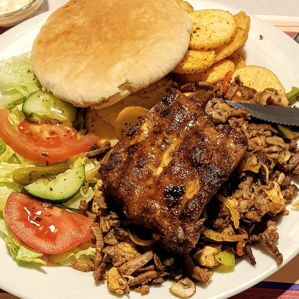 Grillschotel met spareribs, gekruid vlees, pita, aardappeltjes en salade