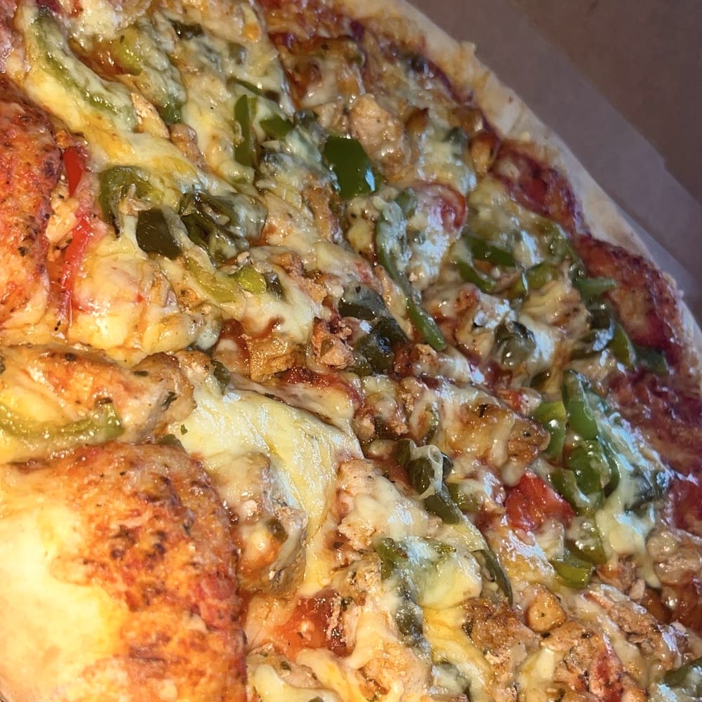 Pizza met paprika, kip en gesmolten kaas